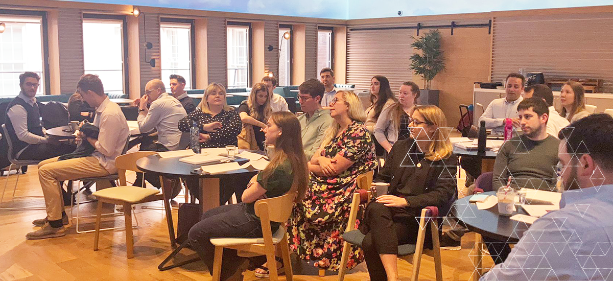 Man climbing rock, with friends supporting underneath